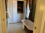 Sink and toilet behind another pocket door off laundry and tub room